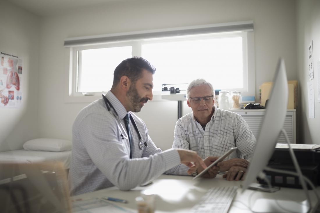 doctor showing clipboard to patient in office discussing immunodeficiency disorders